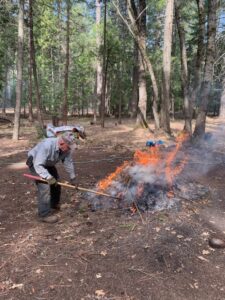 Volunteer tending a burn pile at the Wherrit Property, Rainbow Ridge